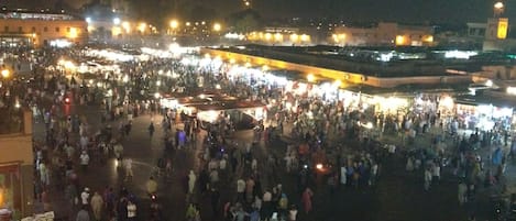 Un marché animé en plein air, de nuit, avec de nombreux étals et beaucoup de monde.