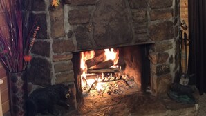 A stone fireplace with a wooden mantel, decorated with autumn leaves, pumpkins, and candles. - Hear the Waterfalls: Quiet Escape Near Downtown Gatlinburg (Gatlinburg)