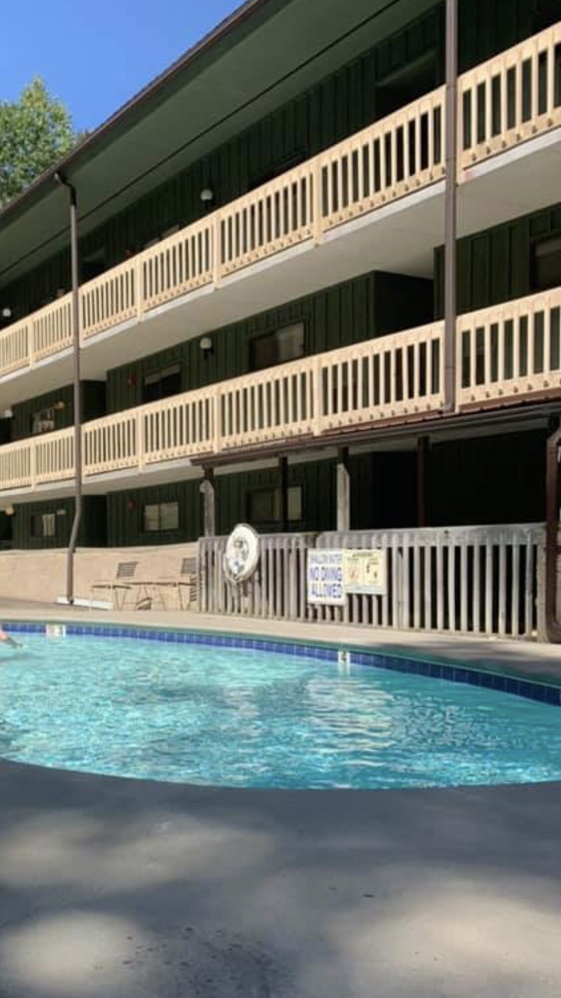Ein Hotel mit Pool, mehreren Balkonen und einem Schild, das eine autofreie Zone kennzeichnet.