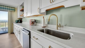 A modern kitchen with white cabinetry, a stainless steel sink, and a wooden countertop. - New listing!  Two bedroom, 2 bath with heated pool (Ocean City)