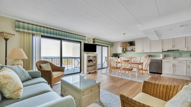 A spacious living area with a sofa, chairs, a dining table, and a kitchen in the background. - New listing!  Two bedroom, 2 bath with heated pool (Ocean City)