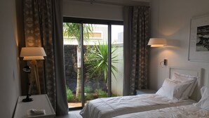 A hotel room with two beds, a desk, a lamp, and a view of greenery outside. - VILLA LUXURY 220 m2 private pool Royal Park secure quiet (Moka)