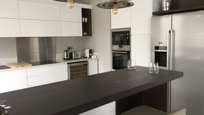 A modern kitchen with a central island, stainless steel appliances, and pendant lighting. - VILLA LUXURY 220 m2 private pool Royal Park secure quiet (Moka)
