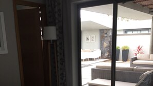 A hotel room with a bed, a large window, and a view of the outdoor seating area. - VILLA LUXURY 220 m2 private pool Royal Park secure quiet (Moka)