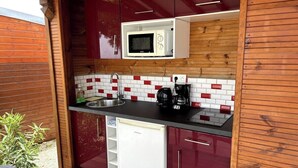 A compact kitchen with a microwave, coffee maker, and a small refrigerator. - Adrien Caraïbes • Domaine de Meilly (Saint-Louis)