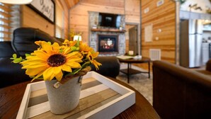 Interior acogedor de una cabaña con chimenea, paredes de madera y un comedor.