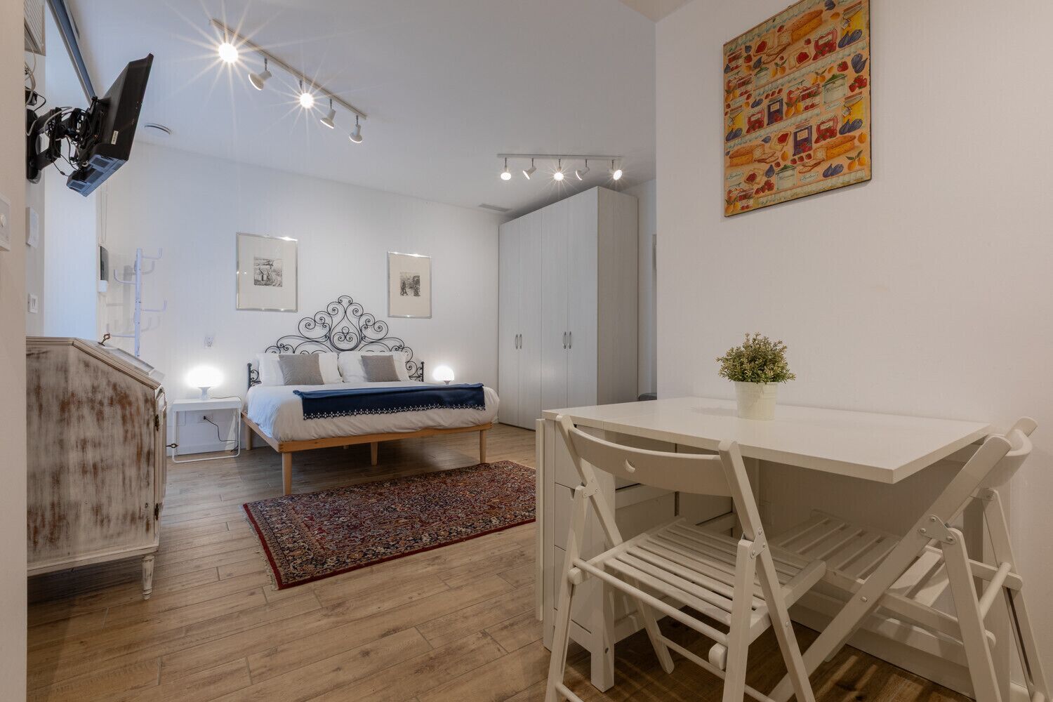 A modern bedroom with a bed, bedside tables, a desk, and a chair.