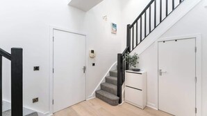 A staircase with a black railing, white walls, and a grey carpeted floor. - Free Secure Parking | Stunning City Views (York)
