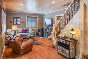 A cozy living room with a fireplace, a sofa, a coffee table, and a television.