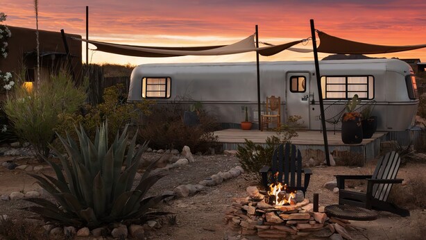 A stationary RV with a deck, surrounded by desert plants and a fire pit. - Air Conditioned Escape ⁠— Quick Drive from Big Ben (Terlingua)