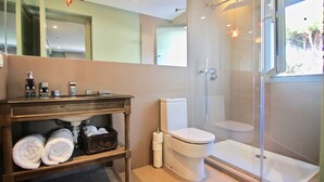 A bathroom with a toilet, a shower, a sink, and a mirror. - 2 bedroom apartment, Roche (Roche)
