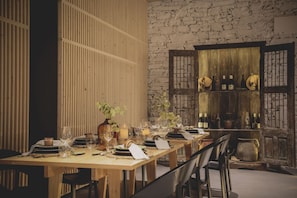 A dining table set with plates, glasses, and candles, surrounded by chairs. - Casal dos Capelinhos - Quinta Nova (Santa Marta de Penaguião)