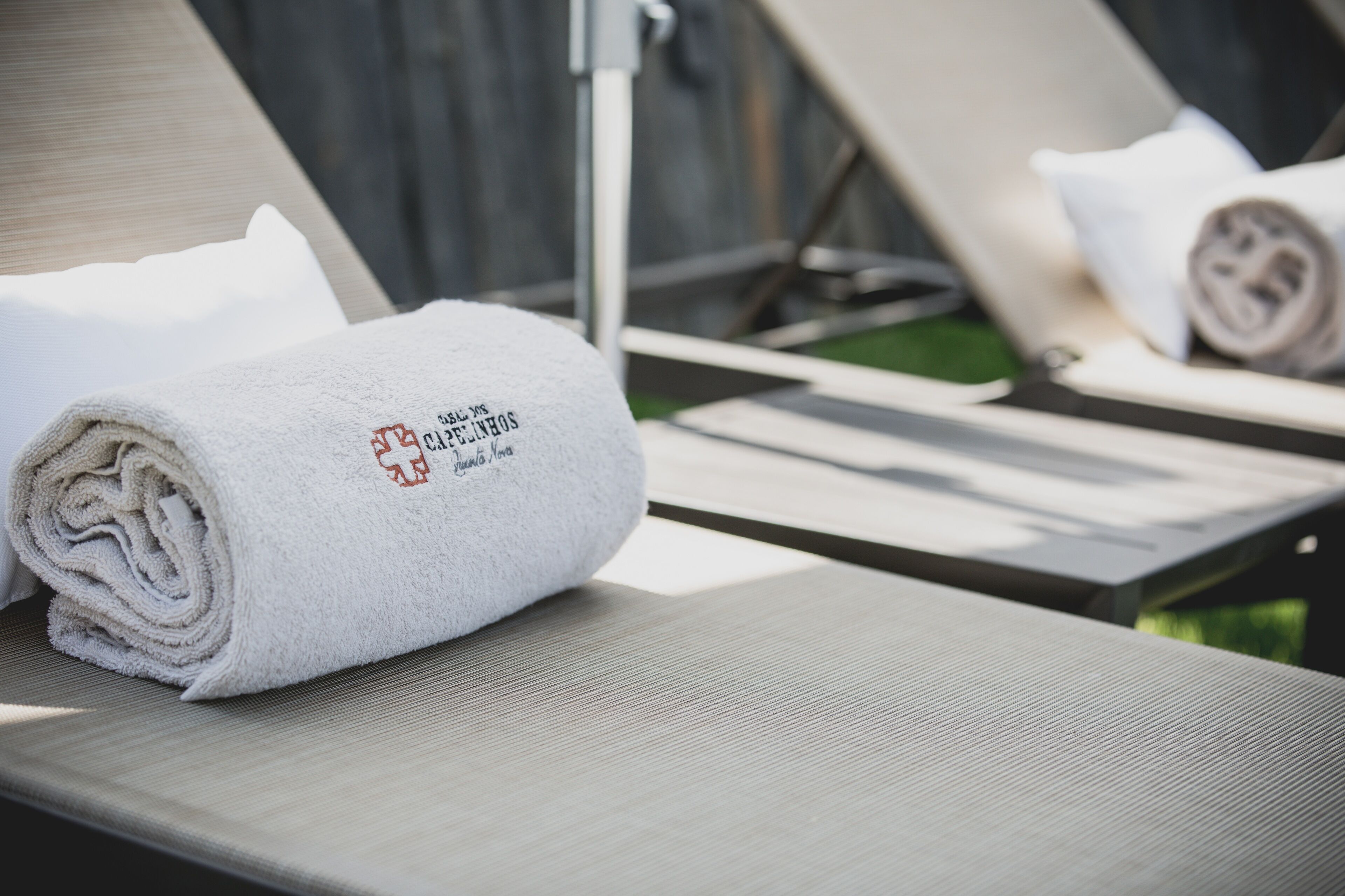 A towel with a logo on a lounge chair.