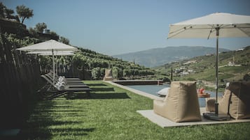 Una piscina al aire libre de temporada, sombrillas