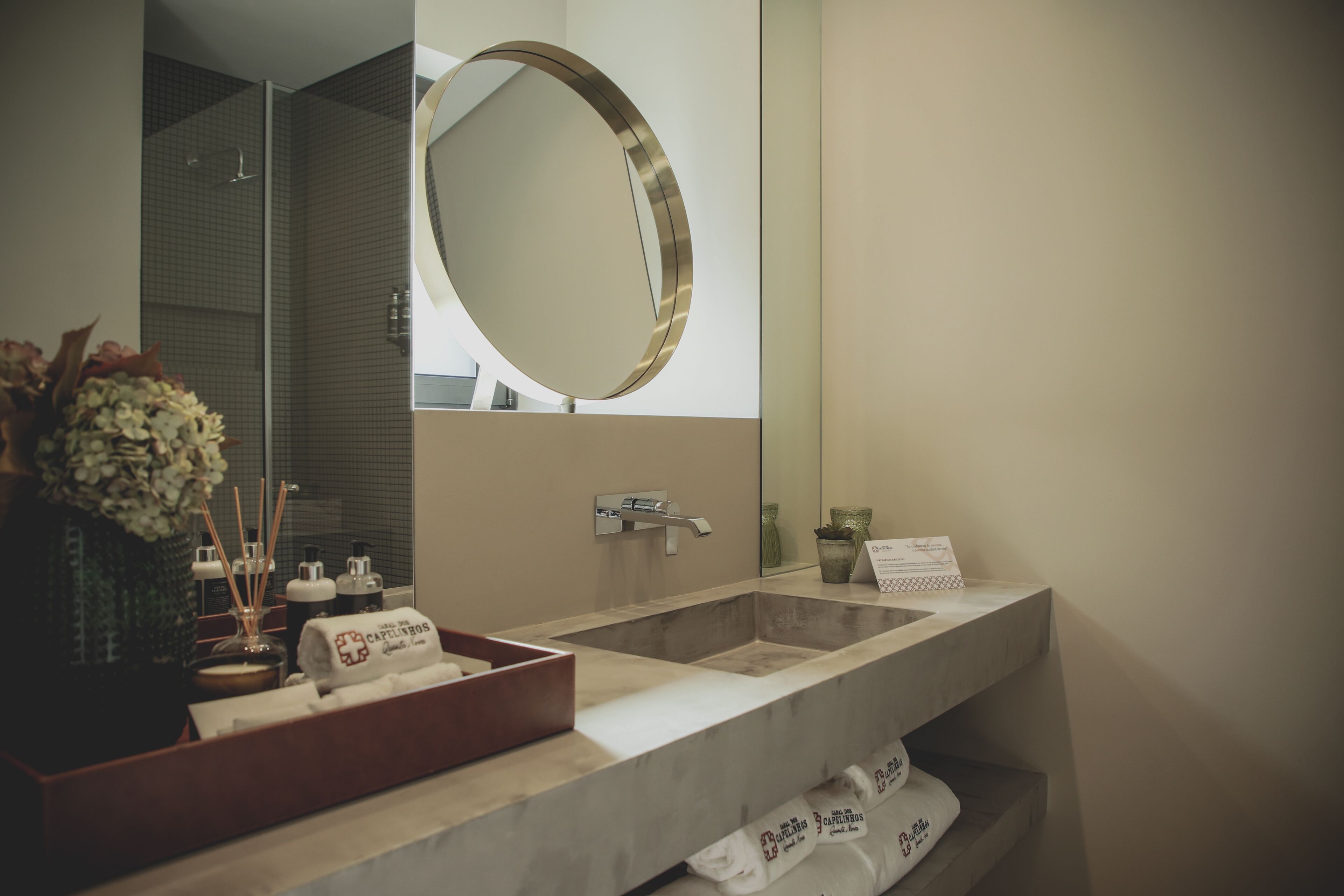 Un baño moderno con un espejo grande, un lavamanos de mármol y un perchero para toallas.