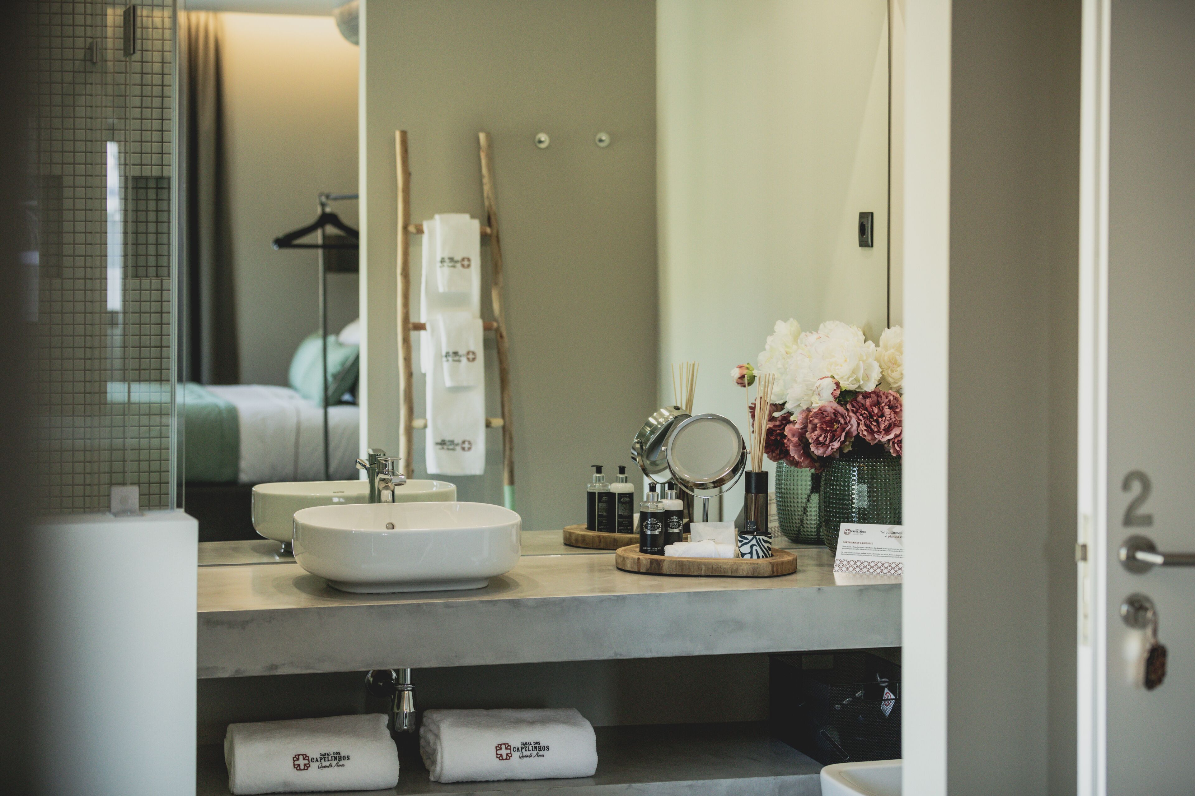 A modern bathroom with a large mirror, two sinks, and a vanity area.