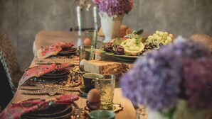 A dining table set with plates, glasses, and a variety of fruits and vegetables. - Casal dos Capelinhos - Quinta Nova (Santa Marta de Penaguião)