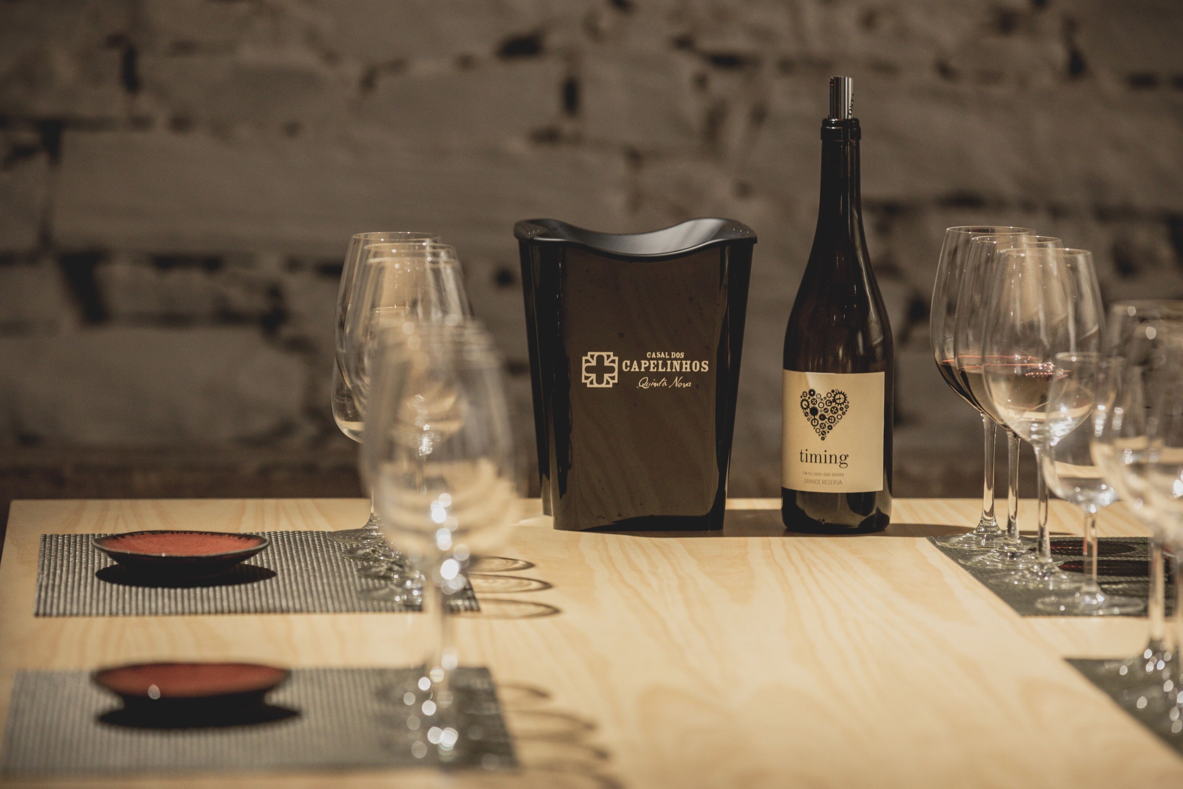A table set with wine glasses, a bottle of wine, and a menu.
