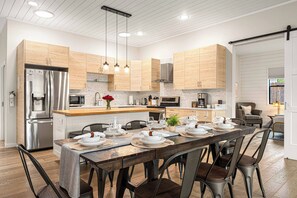 Una cocina moderna con armarios de madera, electrodomésticos de acero inoxidable y una zona de comedor lista para una comida.