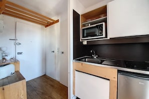 A compact kitchen with a microwave, sink, and dishwasher.