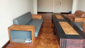 A room with a wooden coffee table, a grey sofa, and a brown leather sofa.