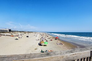 A beach with a wooden boardwalk, sandy beach, and ocean waves. - Corner Condo Oasis with Balcony, Pool Views & Hot Tub Access, Steps to South Beach! (Tybee Island)