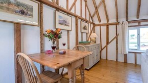 Ein Essbereich mit Holztisch, Stühlen und gerahmten Bildern an der Wand.