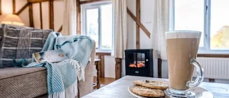 A cozy room with a wooden table, a glass mug of coffee, and cookies.