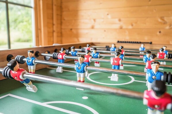 Une table de baby-foot avec des joueurs portant des maillots rouges et bleus.