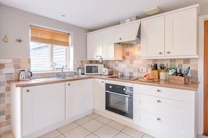 Enjoy cooking in this well-equipped kitchen with oven, microwave, and sink.
