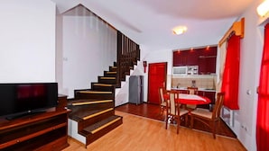 A modern apartment with a wooden staircase, a dining area, and a kitchen. - Kraljevi Konaci Zlatibor (Zlatibor)