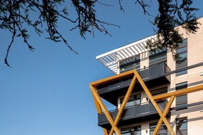 A modern building with a unique geometric design, featuring balconies and large windows. - City Views | Lifestyle Loft | Zuni Lofts (Denver)