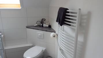 Un bagno compatto con il water, un portasciuga e un termosifone.