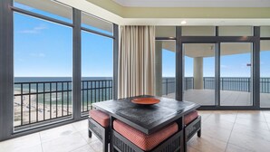 A balcony with a table and chairs, large windows with a view of the beach and ocean, and a sliding glass door. - New to the Rental Market!!  Lazy River, Waterslide!! (Bouvet Island)