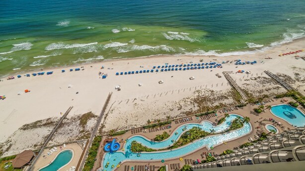 An aerial view of a beach resort with a large sandy beach, multiple swimming pools, and a boardwalk leading to the beach. - New to the Rental Market!!  Lazy River, Waterslide!! (Bouvet Island)
