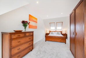 Un dormitorio con cama, cómoda y un cuadro en la pared.