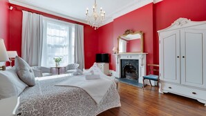 A bedroom with a bed, a television, a fireplace, and a wardrobe. - 5 Bed in Torquay (oc-bcvane) (Torquay)
