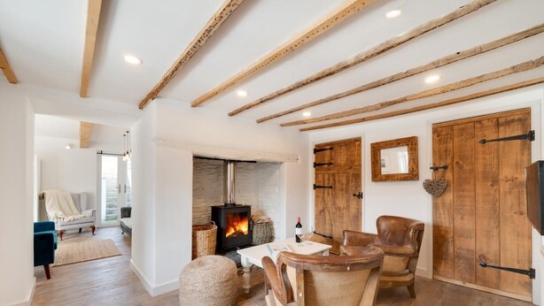 A cozy living room with a fireplace, wooden beams, and rustic furniture. - 3 Bed in Croyde (oc-croyco) (Braunton)