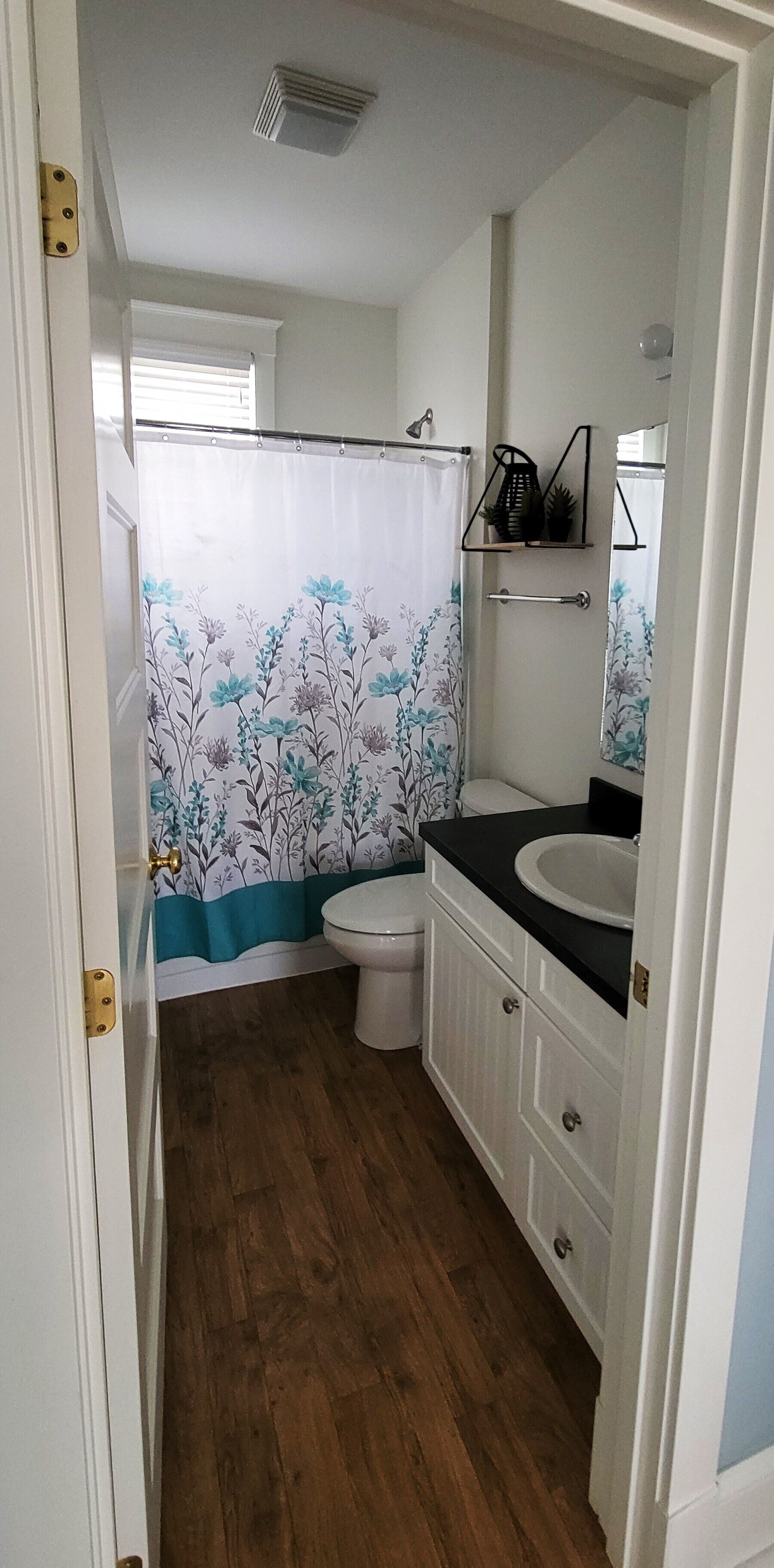 Un baño con inodoro, lavabo y cortina de ducha.