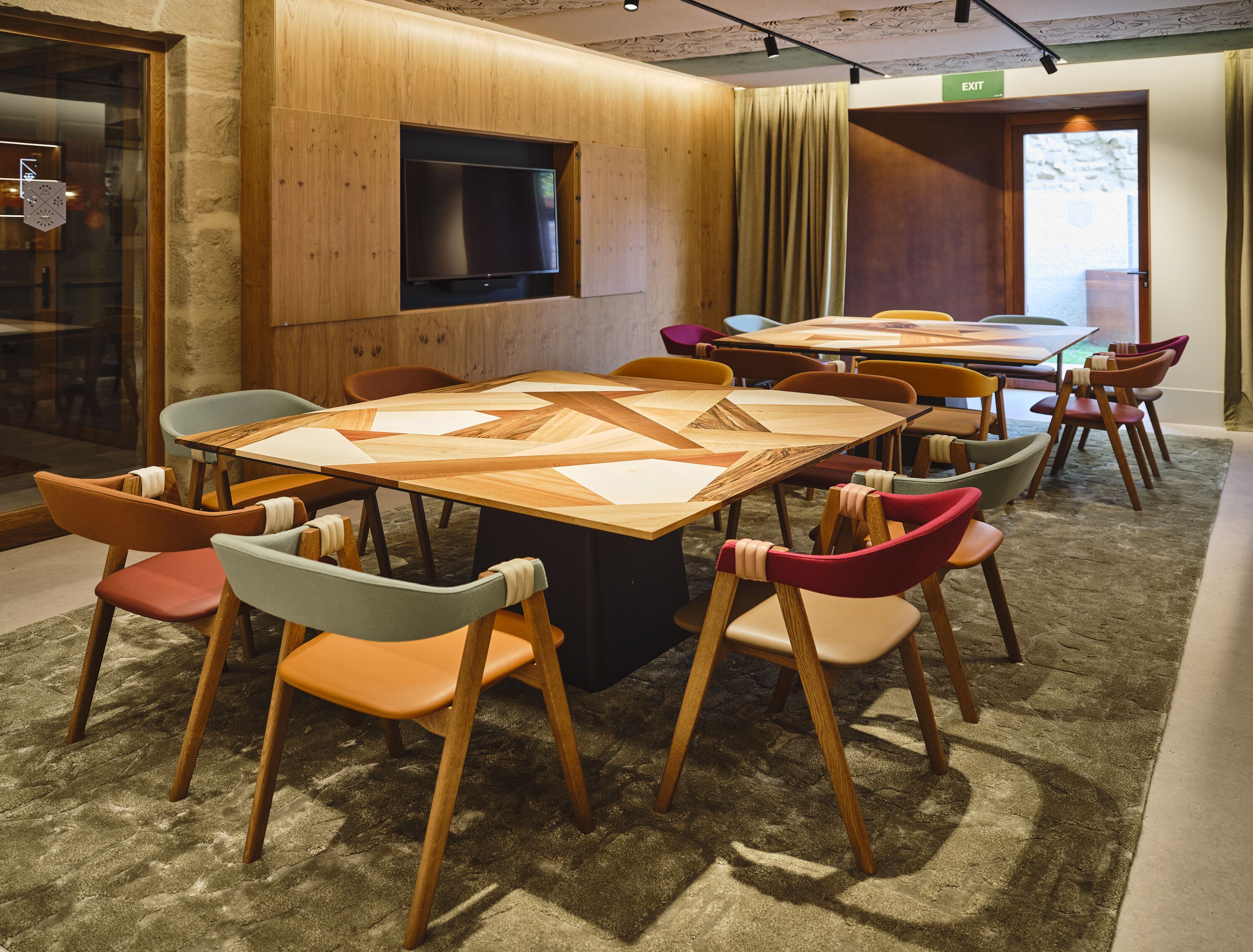 Una sala de conferencias con una mesa grande, varias sillas y una televisión.