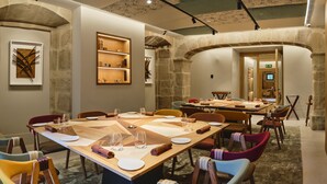 Un comedor con una mesa larga dispuesta para varias personas, rodeada de sillas.