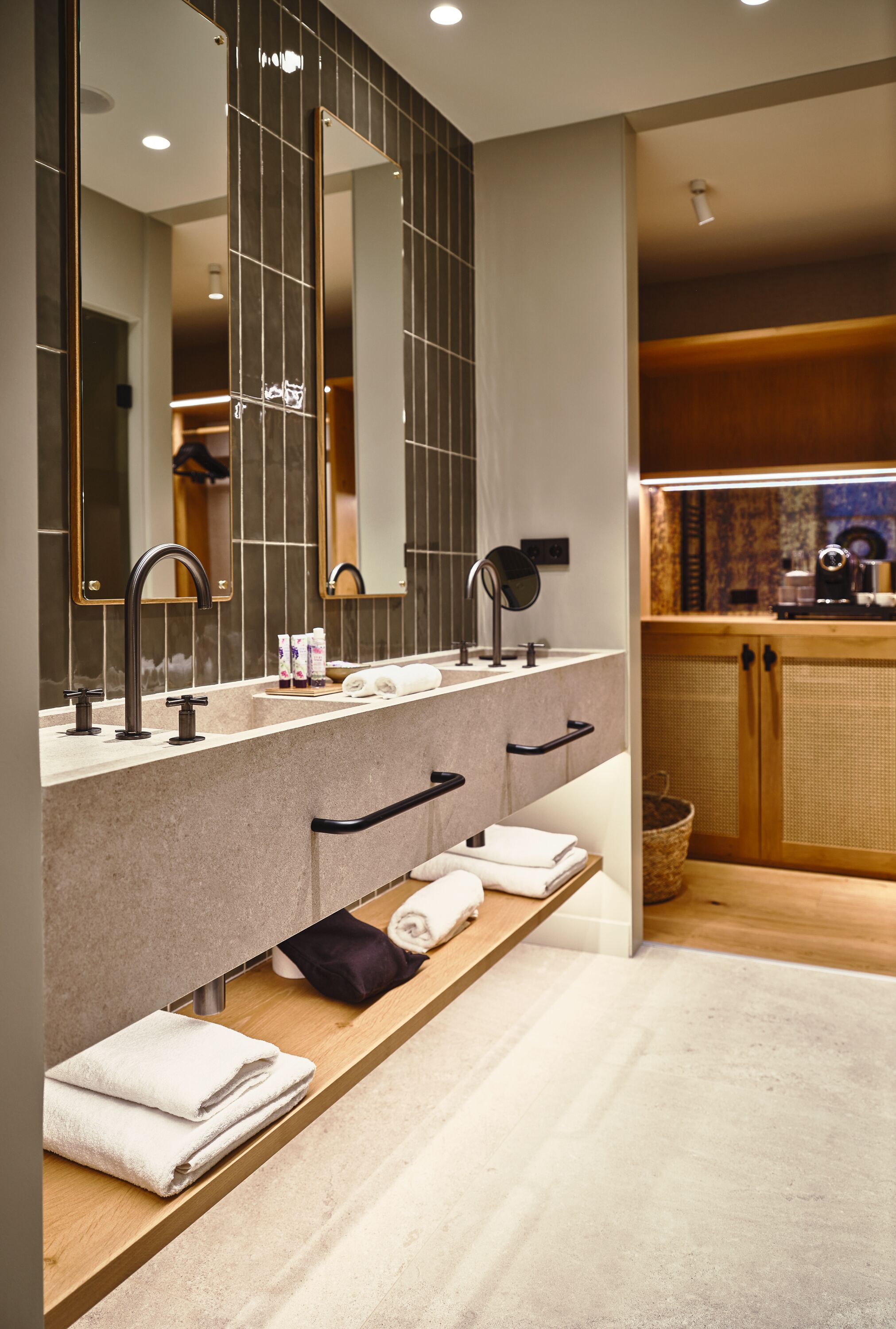 Un baño moderno con un espejo grande, lavamanos dobles y un mueble de tocador de madera.