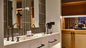 Un baño moderno con un espejo grande, lavamanos dobles y un mueble de tocador de madera.