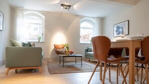 Un salon moderne comprenant un canapé, un fauteuil, une table basse et un coin repas avec des chaises et une table.