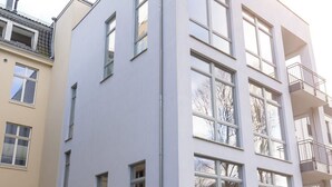Un immeuble moderne à plusieurs étages, doté de grandes fenêtres et de balcons.