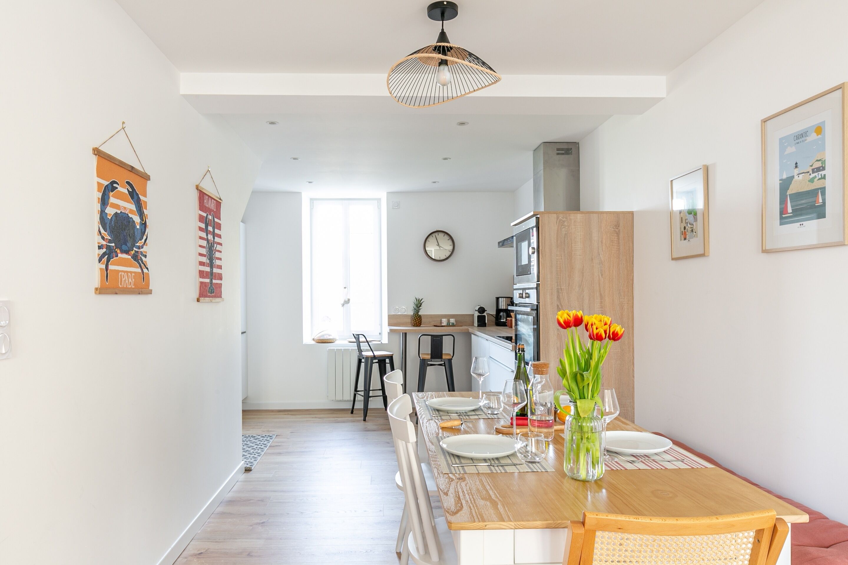 A modern kitchen with a wooden countertop, a dining area with a wooden table, and a view of the adjacent living space.