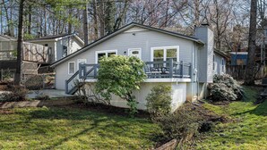 A single-story house with a front deck, a small staircase, and a fenced yard. - 4BR Home Minutes to DOWNTOWN, RAD & BILTMORE (Arden)