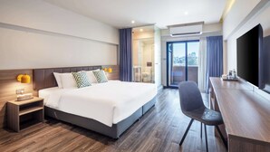 Een moderne hotelkamer met een groot bed, een bureau en een televisie.