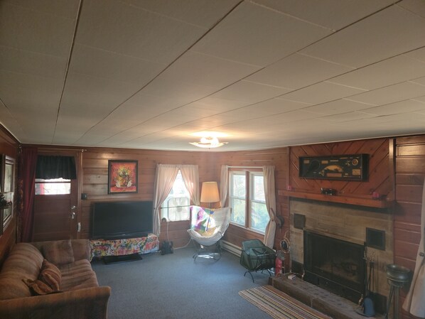A cozy living room with a fireplace, a television, and a comfortable sofa.