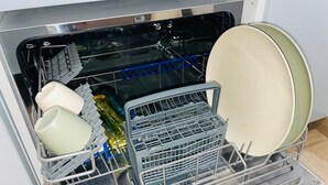 Ein Geschirrspüler mit Innenraum, der verschiedene Geschirrteile und Besteck enthält.